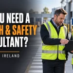 Two professionals reviewing a clipboard in an industrial workplace beside a headline about health and safety consultancy.